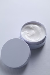 Photo of Face cream in jar on white textured table