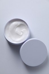 Face cream in jar on white textured table, top view