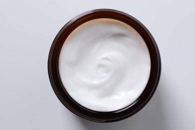 Face cream in jar on white background, top view