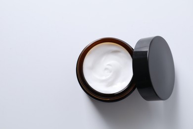 Photo of Face cream in jar on white background, top view. Space for text