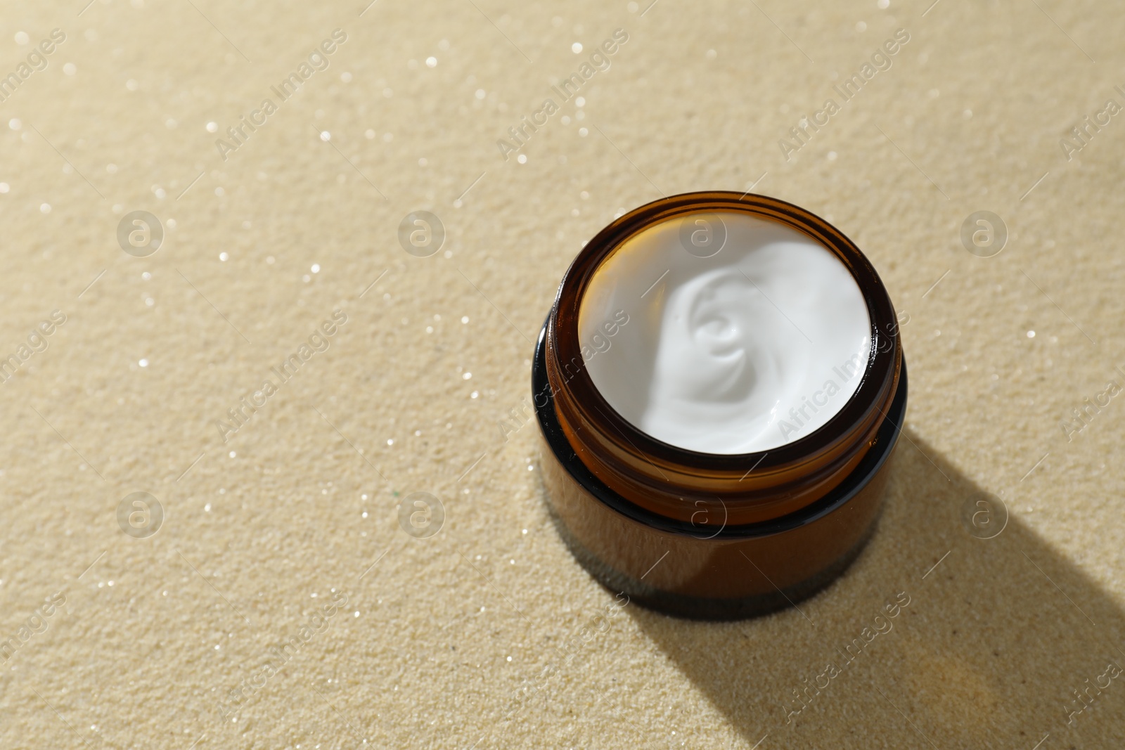 Photo of Face cream in jar on beige textured background. Space for text