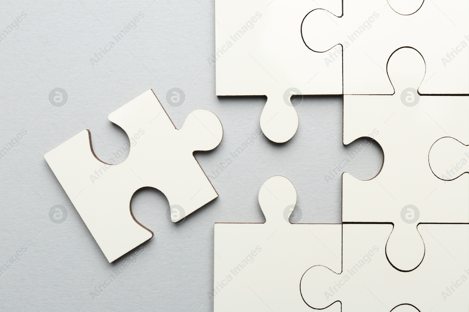 Photo of White puzzle pieces on grey background, top view