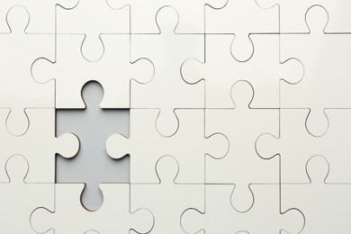 Photo of White puzzle with missing piece on grey background, top view