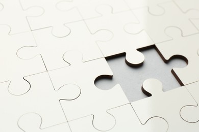 Photo of White puzzle with missing piece on grey background, closeup