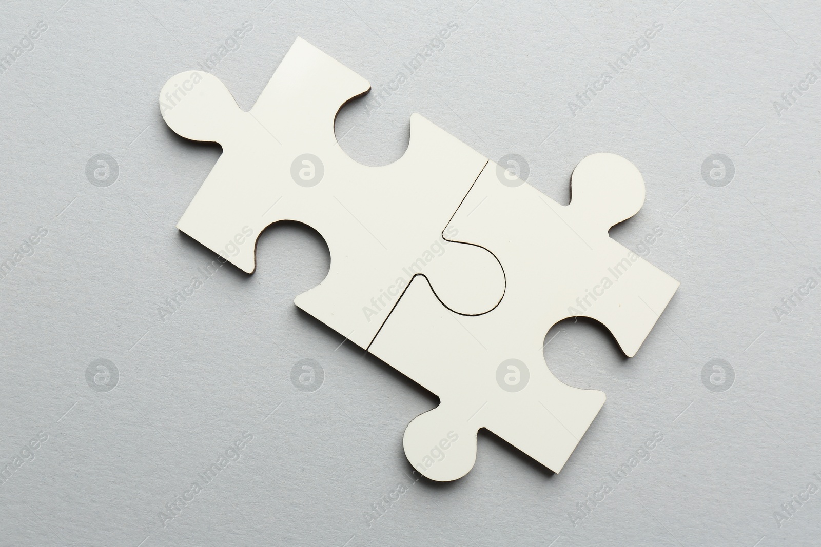 Photo of White puzzle pieces on grey background, top view