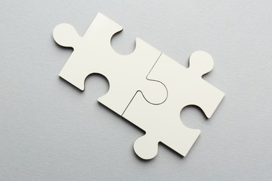 Photo of White puzzle pieces on grey background, top view