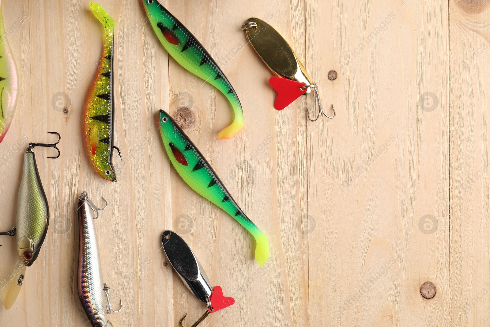 Photo of Different fishing tackles on wooden table, flat lay. Space for text