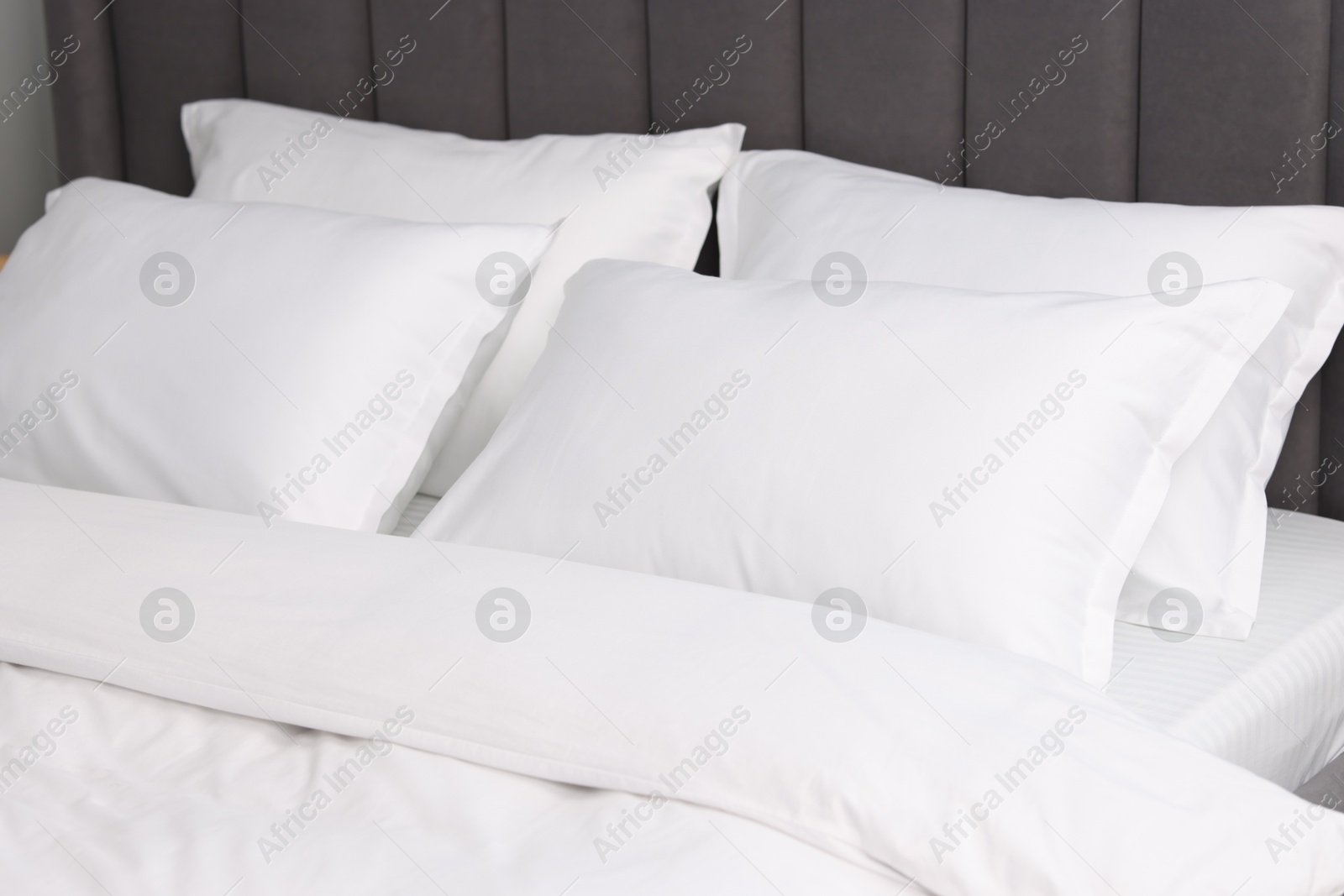 Photo of Many soft pillows on bed at home, closeup