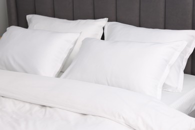 Many soft pillows on bed at home, closeup