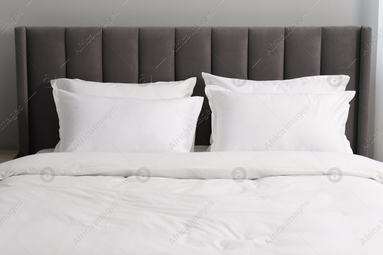 Photo of Many soft pillows on bed at home