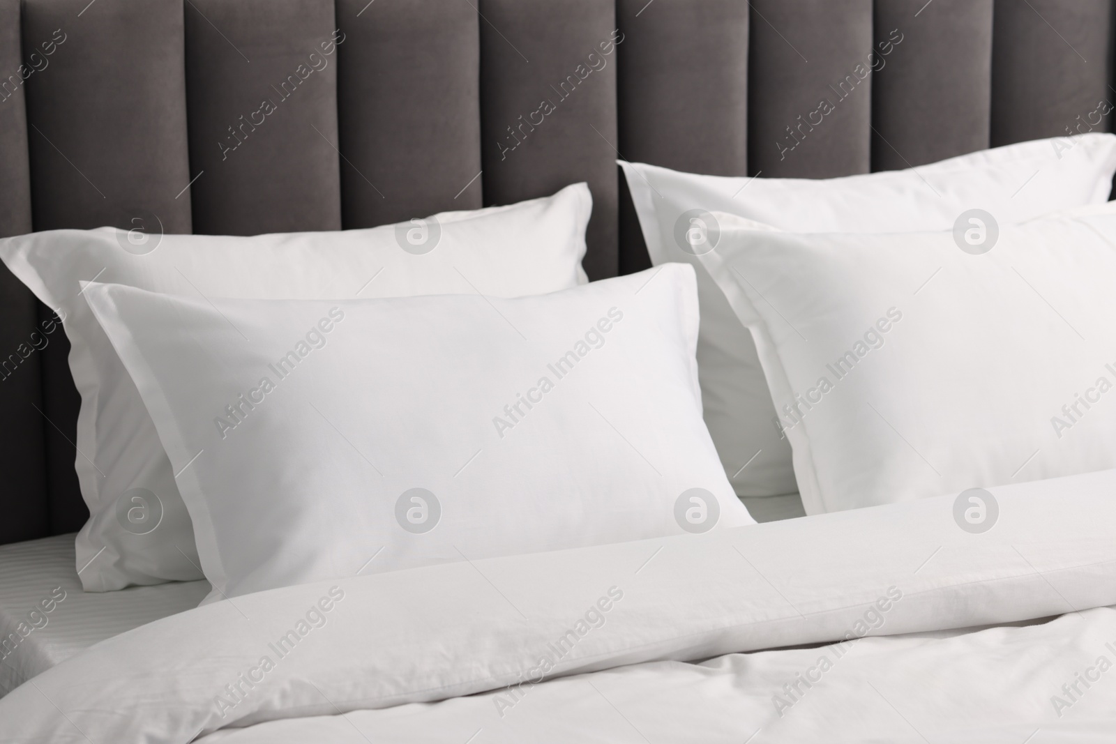 Photo of Many soft pillows on bed at home, closeup