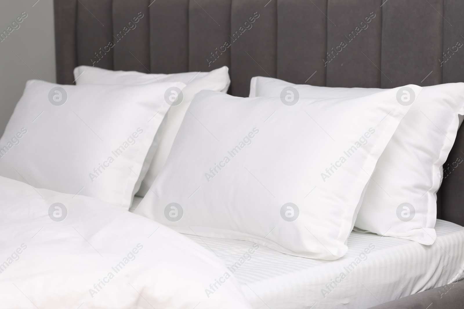 Photo of Many soft pillows on bed at home, closeup