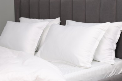 Many soft pillows on bed at home, closeup