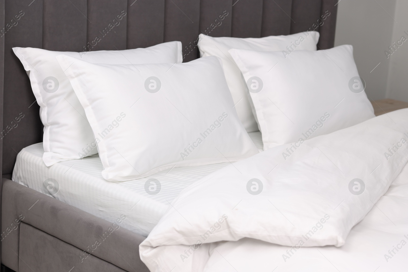 Photo of Many soft pillows on bed at home, closeup