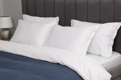 Photo of Many soft pillows on bed at home, closeup