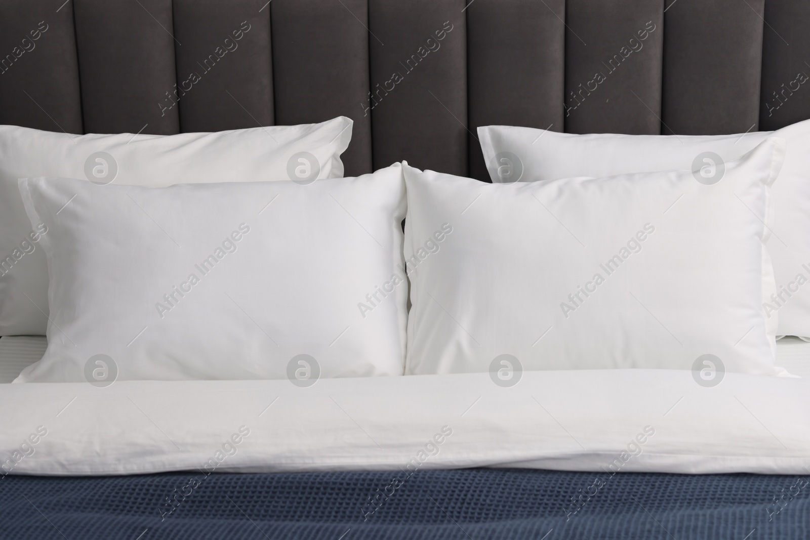 Photo of Many soft pillows on bed at home, closeup