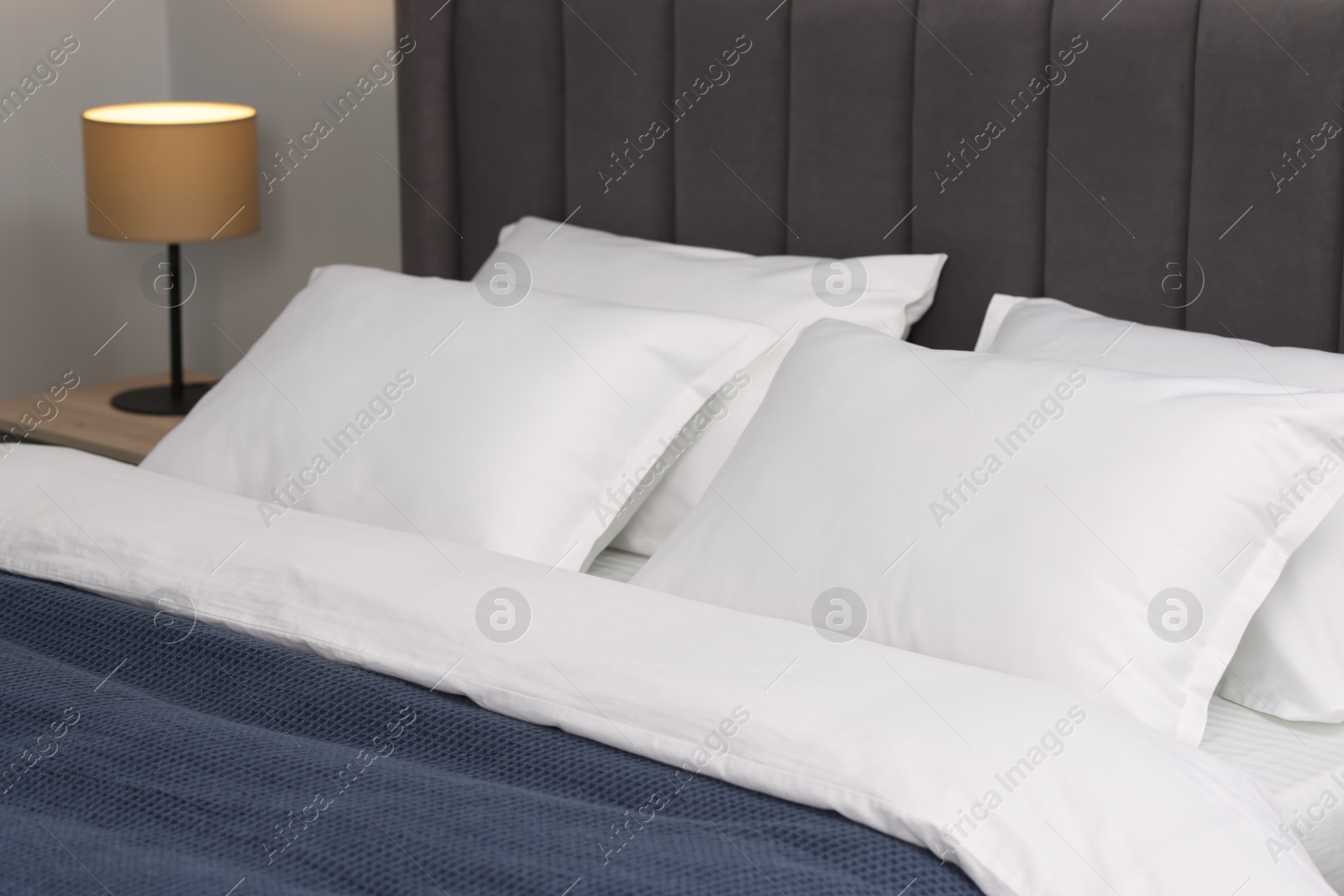 Photo of Many soft pillows on bed at home, closeup