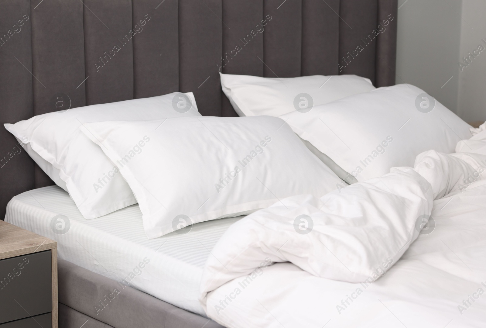 Photo of Many soft pillows on bed at home