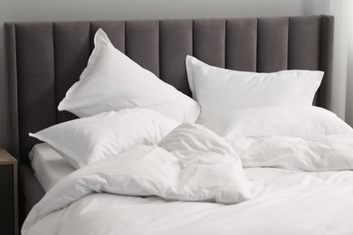 Photo of Many soft pillows on bed at home