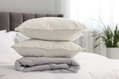 Soft pillows and duvet on bed at home