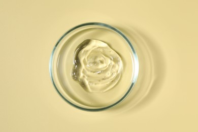 Petri dish with sample on beige background, top view