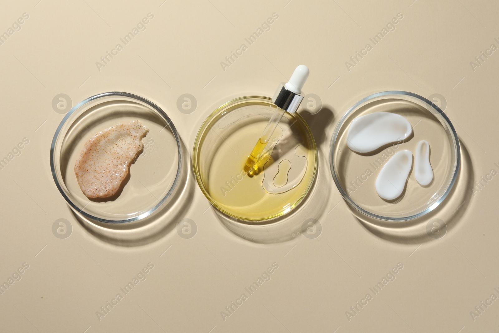 Photo of Petri dishes with different cosmetic products on beige background, flat lay