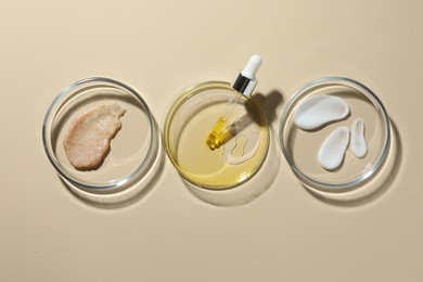 Petri dishes with different cosmetic products on beige background, flat lay