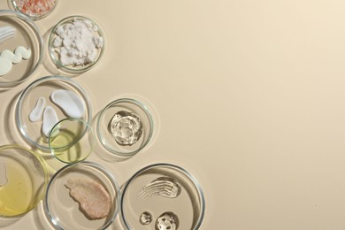 Petri dishes with different cosmetic products on beige background, flat lay. Space for text