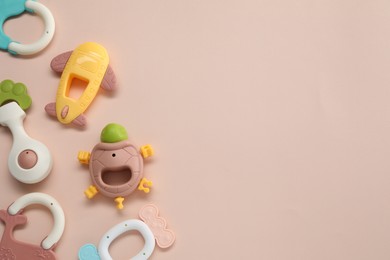 Colorful rattles on beige background, flat lay with space for text. Baby accessories