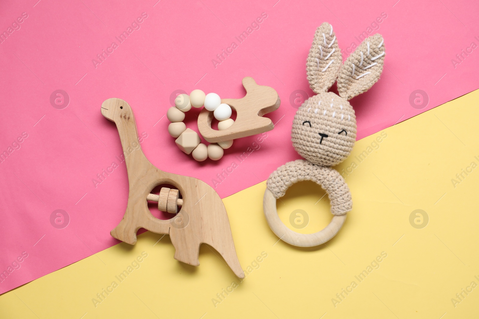 Photo of Wooden rattles on color background, flat lay. Baby accessories