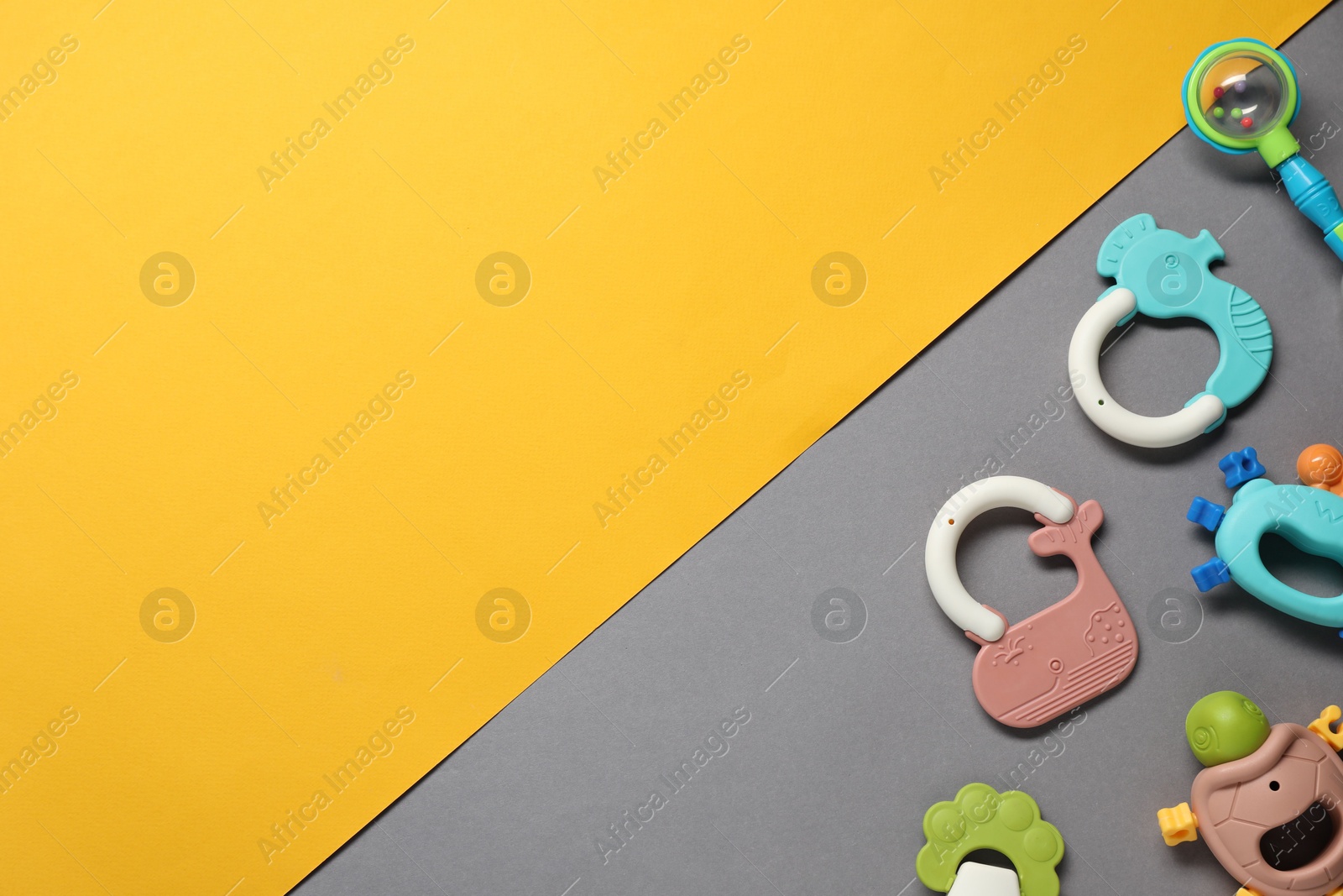 Photo of Different baby rattles on color background, flat lay. Space for text