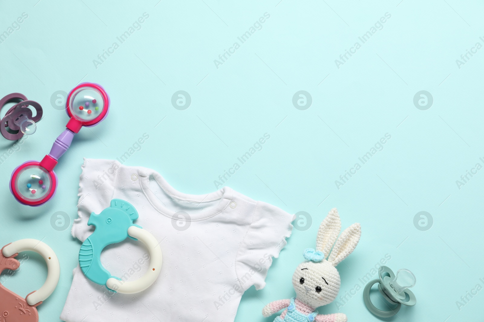 Photo of Baby accessories on light blue background, flat lay. Space for text