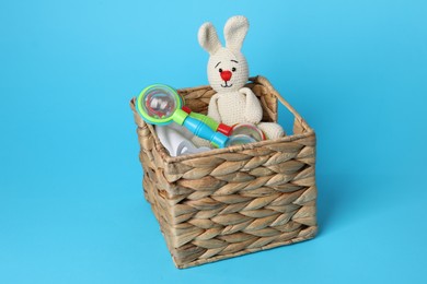 Different baby accessories in box on light blue background