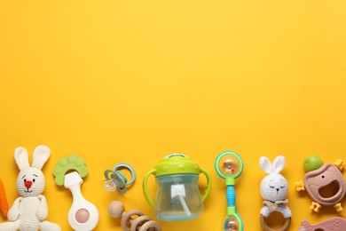 Photo of Different baby rattles on yellow background, flat lay. Space for text