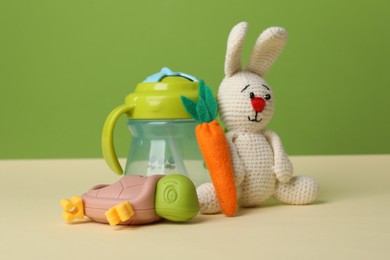 Photo of Baby toys and bottle on beige table