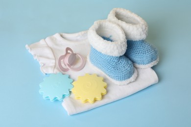 Different baby accessories on light blue background