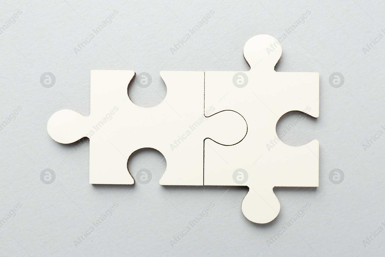 Photo of White puzzle pieces on grey background, top view