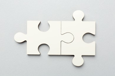 White puzzle pieces on grey background, top view