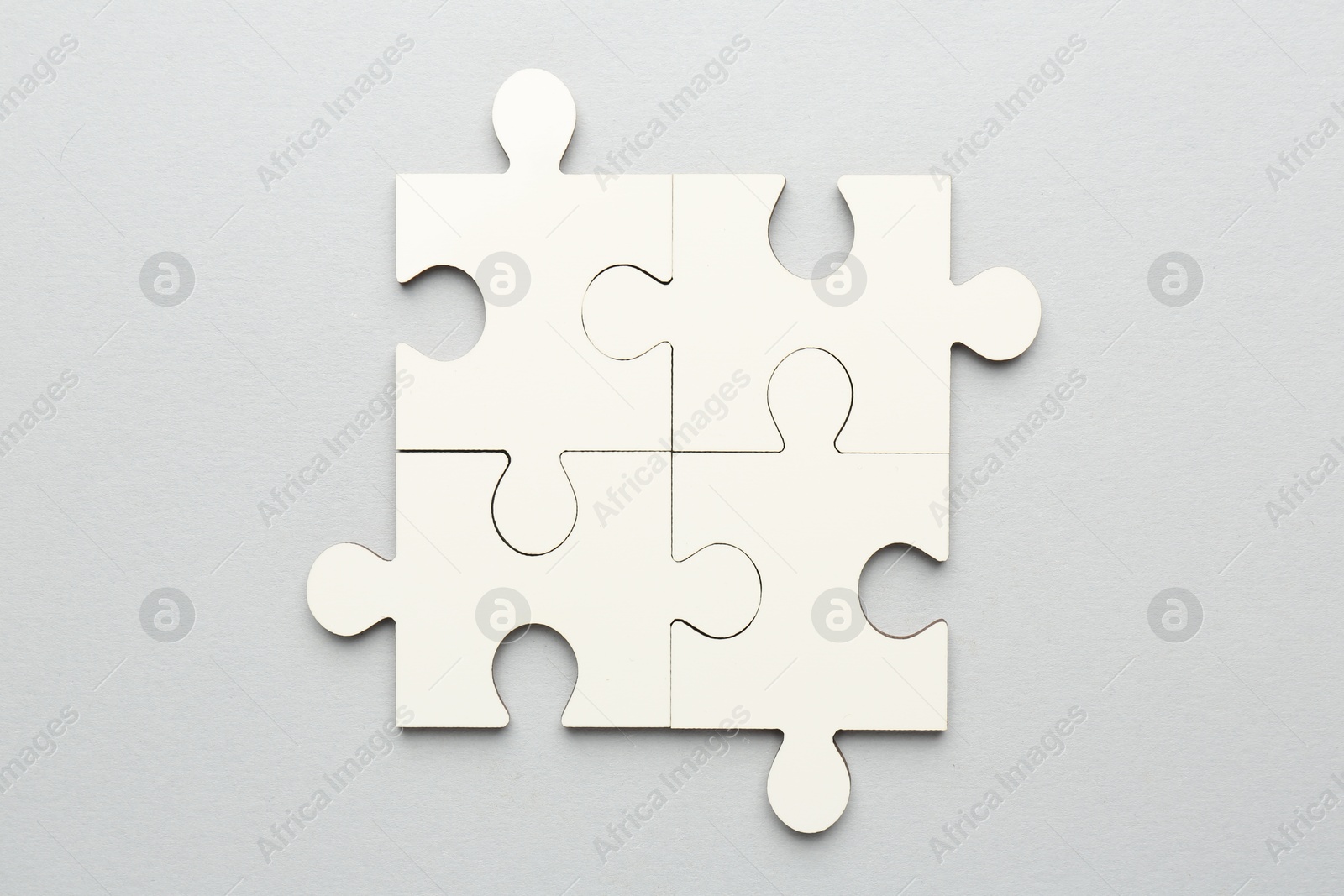 Photo of White puzzle pieces on grey background, top view