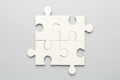 Photo of White puzzle pieces on grey background, top view