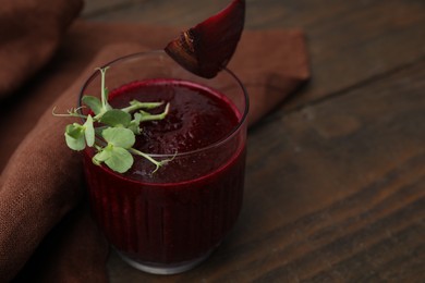 Vegan drink. Tasty beetroot smoothie with microgreens in glass on wooden table, closeup. Space for text