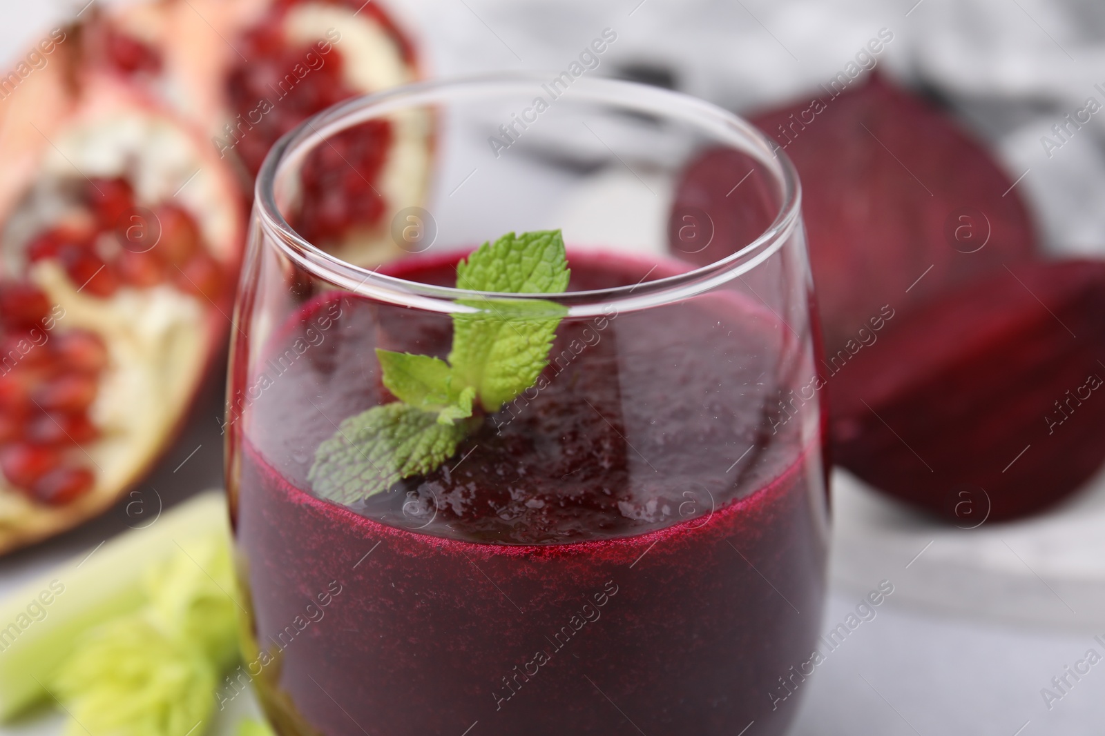 Photo of Tasty beetroot smoothie with mint in glass on table, closeup. Vegan drink