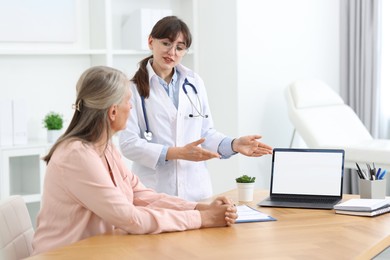 Lung disease. Doctor showing something on laptop to her patient in clinic