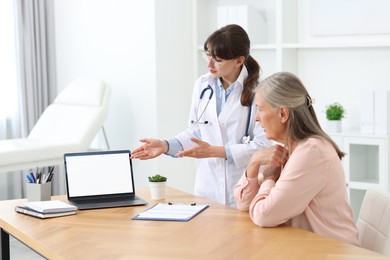 Photo of Lung disease. Doctor showing something on laptop to her patient in clinic