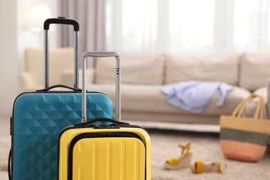 Photo of Light blue and yellow suitcases at home, space for text