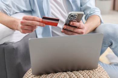 Photo of Online banking. Man with credit card and laptop paying purchase at home, closeup