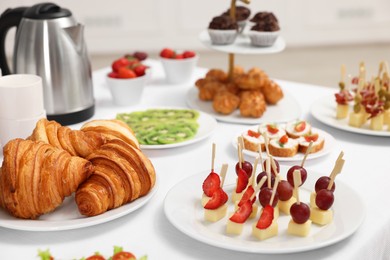 Different meals served on white table indoors. Buffet menu