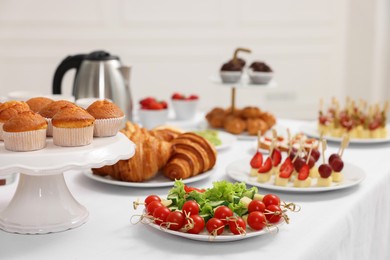 Different meals served on white table indoors. Buffet menu