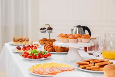 Different meals served on white table indoors. Buffet menu