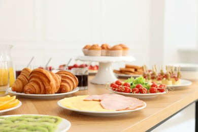 Different meals served on wooden table indoors. Buffet menu